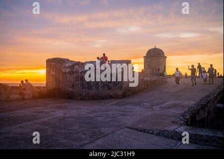 I visitatori possono ammirare il tramonto dalla cima delle mura della città vecchia di Cartagena, Colombia Foto Stock