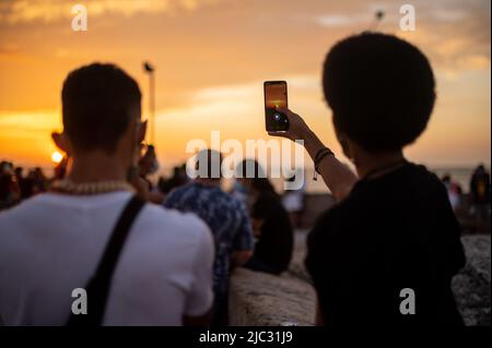 I visitatori possono ammirare il tramonto dalla cima delle mura della città vecchia di Cartagena, Colombia Foto Stock