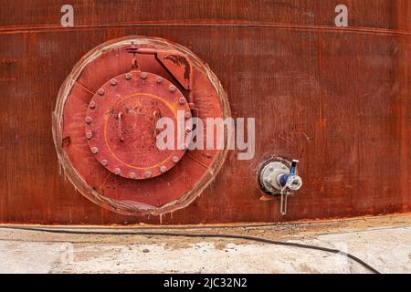 Aprire il tombino arrugginito sul serbatoio di stoccaggio del serbatoio del carburante Foto Stock