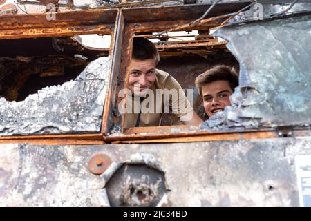 Kiev, Ucraina. 09th giugno 2022. Giovani uomini partecipano ad una esposizione di veicoli distrutti della guerra russi esposti a Piazza Michailovskyi in una città vecchia di Kyiv, Ucraina il 9 giugno 2022. Mentre la Federazione russa ha invaso l'Ucraina 3 mesi e mezzo fa, continuano feroci combattimenti nell'est del paese. La capitale, Kyiv rimane in relativa sicurezza, anche se i richiami della guerra come le borse di sabbia protettive, i blocchi stradali, i simboli nazionali e anti-guerra sono presenti in tutta la città. (Foto di Dominika Zarzycka/Sipa USA) Credit: Sipa USA/Alamy Live News Foto Stock