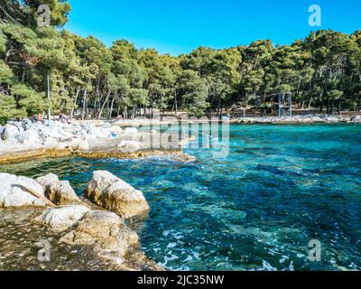 Spiaggia di Kupalište bene con sedie a sdraio presso la costa rocciosa del Parco della Foresta di Marjan nella città di Spalato, Croazia Foto Stock