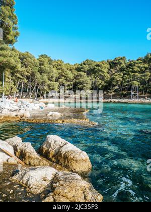 Spiaggia di Kupalište bene con sedie a sdraio presso la costa rocciosa del Parco della Foresta di Marjan nella città di Spalato, Croazia Foto Stock
