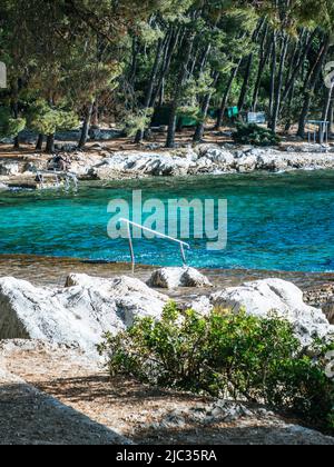 Spiaggia di Kupalište bene con sedie a sdraio presso la costa rocciosa del Parco della Foresta di Marjan nella città di Spalato, Croazia Foto Stock