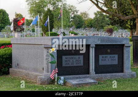 Una bandiera americana e una piccola statua di cherubini adornano il cimitero dell'ex United States Sen. Wendell Hampton Ford (1924-2015) il Memorial Day, Lunedi, 30 maggio 2022 a Rosehill-Elmwood Cemetery & Mausoleum a Owensboro, Daviess County, KY, USA. Ford era un veterano che ha servito nell'esercito degli Stati Uniti durante la seconda guerra mondiale ed allora la guardia nazionale dell'esercito del Kentucky prima di iniziare una carriera politica storied in 1965. (Foto di Apex MediaWire di Billy Suratt) Foto Stock