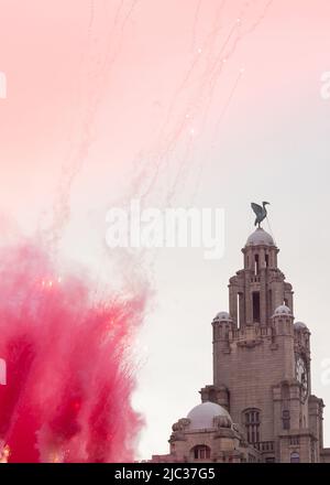 Royal Liver Building, razzi rossi, fumo e fuochi d'artificio durante la sfilata di vittoria che celebra il doppio della coppa nazionale del Liverpool FC 2022, Liverpool, Inghilterra, Regno Unito Foto Stock
