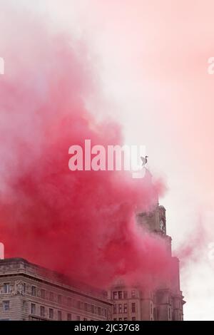 Royal Liver Building, razzi rossi e fumo durante la sfilata di vittoria che celebra il doppio della coppa nazionale del Liverpool FC 2022, Liverpool, Inghilterra, Regno Unito Foto Stock