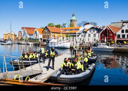 I passeggeri turistici imbarcarsi su imbarcazioni gommabili per un viaggio veloce sui fiordi. Tutti sono in Hi-viz Giacche.Stavanger, Norvegia Foto Stock