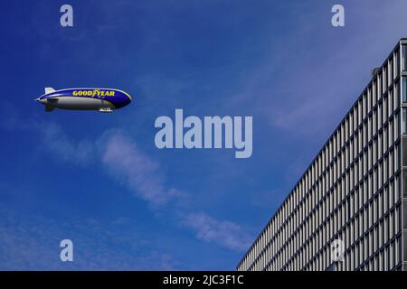 Zeppelin con la pubblicità stampa BUON ANNO vola in cielo blu passando una gru edificio a Colonia. Renania settentrionale-Vestfalia, Germania, 22.5.22 Foto Stock