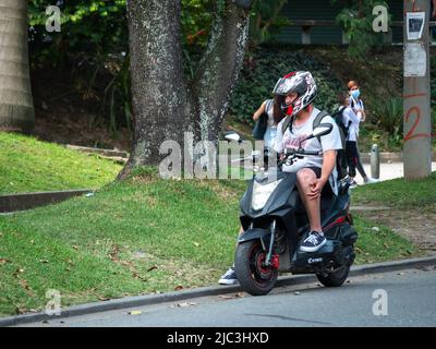 Medellin, Antioquia, Colombia - Febbraio 19 2022: Latino uomo sudamericano che corre una motocicletta è Parcheggio in strada Foto Stock