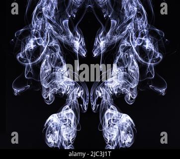 Ricci di fumo senza fuoco illuminato e che si innalzano su uno sfondo nero creando interessanti disegni che si riflettono, Lancaster, Pennsylvania Foto Stock