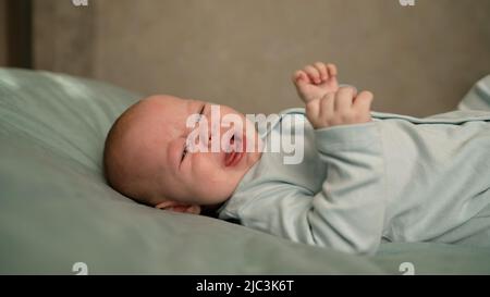 Un ragazzino si trova sul divano ed è pigente. Il bambino è cattivo sul divano. Foto Stock