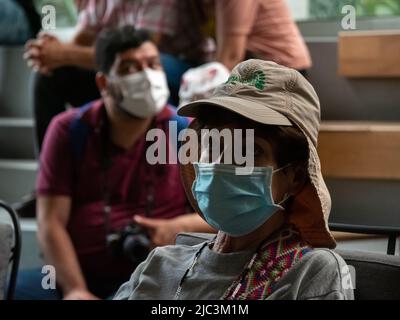 Medellin, Antioquia, Colombia - Febbraio 19 2022: Donna sudamericana con cappuccio marrone e faccia chirurgica blu primo piano Foto Stock