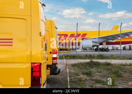 Schkeuditz, Germania - 29th maggio 2022 - molti furgoni corriere contro aerei da carico parcheggiati sul terminal dell'aeroporto di Leipzig Halle per la distribuzione del carico Foto Stock