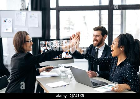 I colleghi multirazziali eccitati hanno fatto un ottimo lavoro, hanno discusso di un nuovo progetto, generando nuove idee, brainstorming tramite videoconferenza con i loro partner commerciali di paesi diversi Foto Stock