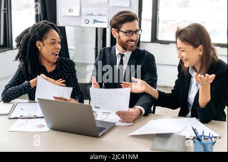 Lavoro di squadra di dipendenti multirazziali, collaborazione. I colleghi gioiosi, che discutono le idee per un nuovo progetto di affari, il brainstorming, stanno parlando del programma finanziario di affari, facendo un affare vantaggioso Foto Stock