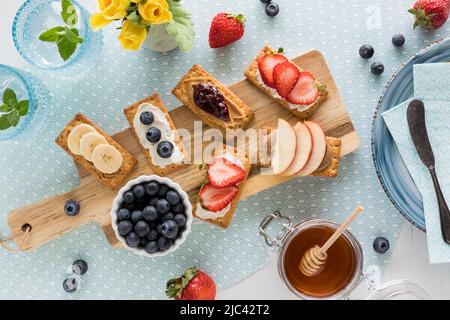 Cracker con frutta fresca, formaggio spalmabile o burro di nocciola, pronti a mangiare. Foto Stock