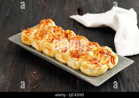 Focus selezionato fatto in casa tirare a parte Pizza Roll pane con formaggio, su tavola di legno Foto Stock