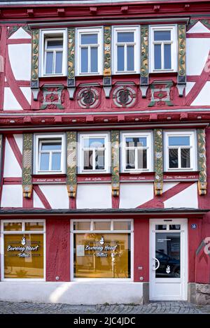 Storica casa a graticcio con travi in legno dipinte e scolpite di colore e stemma familiare, Città Vecchia, Lich, Wetterau, Assia, Germania Foto Stock