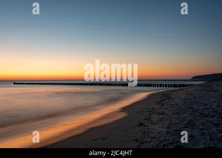 Tramonto con frangiflutti sull'isola di Hiddensee Foto Stock