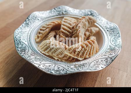 Dolci fatti in casa dalle corna di gazzelle per Ramadan. Primo piano di foto di Kaab El Ghazal appena sfornato, un dolce marocchino, Halal food. Foto Stock