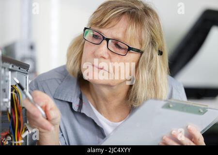 Donna matura il fissaggio di un pc Foto Stock