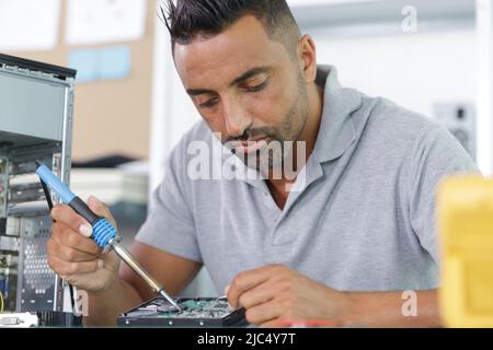 man saldatura di una scheda a circuito stampato Foto Stock