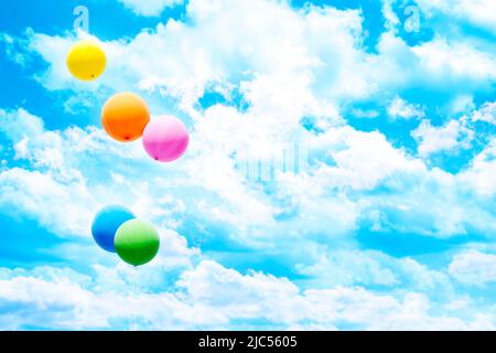 Cinque palloncini colorati sopra il cielo blu e le nuvole bianche. Foto Stock