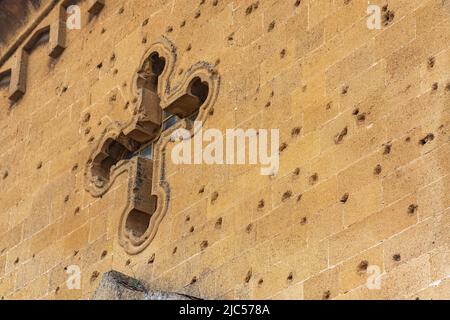 Tracce di pallottole e di shrapnel sul muro di una vecchia chiesa cristiana Foto Stock