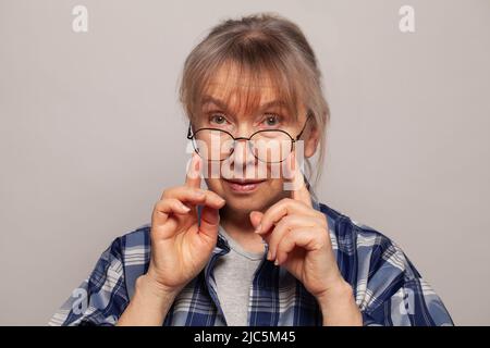 Faccia della donna anziana in occhiali da vicino Foto Stock