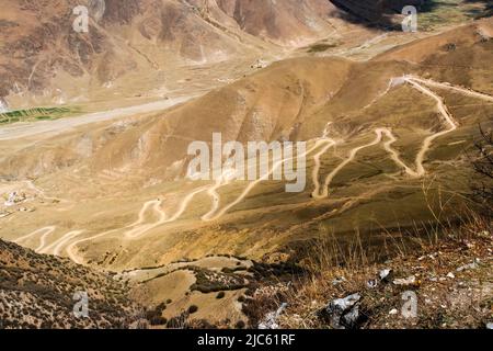 La lunga e tortuosa strada che conduce al Monastero di Ganden a Lhasa, Tibet. Foto Stock