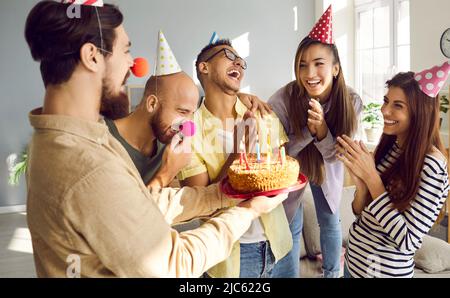 Amici felici saluto ragazza collega con compleanno Foto Stock