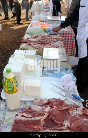 Carni fresche tagliate e formaggi tradizionali venduti in un mercato agricolo in un villaggio rumeno Foto Stock