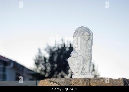Statua del Leone per decorazione con scudo bianco con spazio copia e cielo bianco Foto Stock