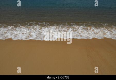 Calme onde marine sulla spiaggia di sabbia tropicale, morbide onde oceaniche sulla spiaggia di sabbia. Foto Stock