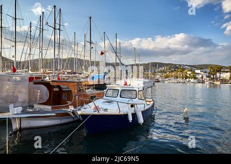 Vista di Bodrum Beach dalla Promenade. Barche a vela, barche a mare Egeo con tradizionali case bianche sulle colline a Bodrum porto città Turchia Foto Stock