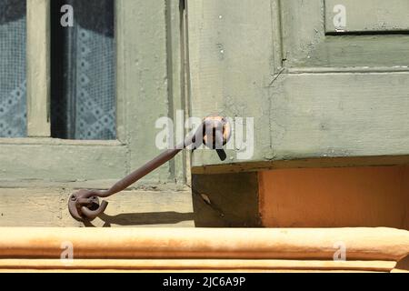 Chiusure per finestre vintage o gancio per serramenti in metallo o gancio per finestre montato su pareti in legno Foto Stock