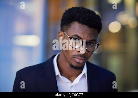 Ritratto di serio sicuro giovane imprenditore afro-americano intelligente con barba che indossa occhiali e vestito Foto Stock