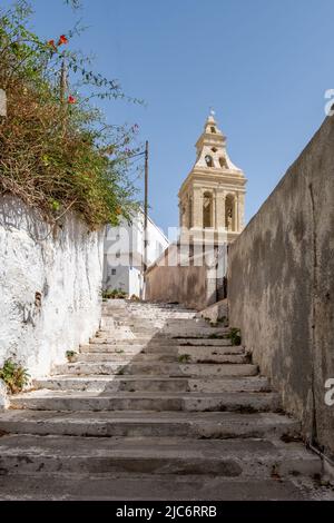 Grecia, isola di Kythira. Scale in pietra salendo, il campanile della chiesa di Agia Anna. Scala stretta vuota a Chora città, cielo blu sfondo. Foto Stock
