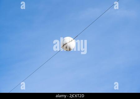 Una sfera di avvertimento bianca su una linea di trasmissione per proteggere l'infrastruttura in Alberta Canada Foto Stock