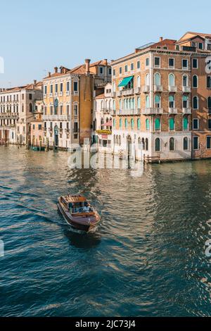 Venezia, Italia - 21 maggio 2022: Taxi acqueo che attraversa il Canal Grande e gli edifici dal ponte di Rialto a Venezia, capitale del Veneto e a Foto Stock