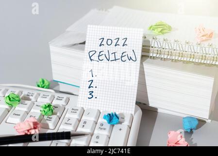 Visualizzazione concettuale 2022 Revisione. Parola per vedere eventi o azioni importanti che hanno reso la signora in vestito tenendo penna simboleggiare successo Foto Stock