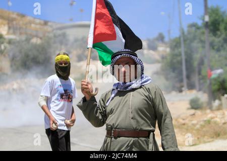 27 maggio 2022, Nablus, Cisgiordania, Palestina: Un manifestante palestinese ha visto sventolare una bandiera, durante la manifestazione contro gli insediamenti israeliani nel villaggio di Kafr Qaddaum vicino alla città di Nablus, in Cisgiordania. (Credit Image: © Nasser Ishtayeh/SOPA Images via ZUMA Press Wire) Foto Stock