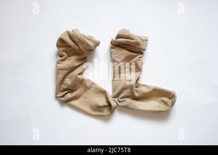 calzini lunghi donna marrone sporco su fondo bianco, calzini usurati Foto Stock