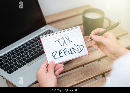 Visualizzazione concettuale del rimborso fiscale. Foto concettuale applicata quando la responsabilità in denaro è inferiore a quella pagata colleghi seduti alla scrivania con documenti per laptop Foto Stock