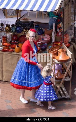 Inusuale stile di vita britannico; una madre e una figlia vestite casual 1950s stile di moda, shopping nel mercato, oggi, Ely Cambridgeshire Regno Unito Foto Stock