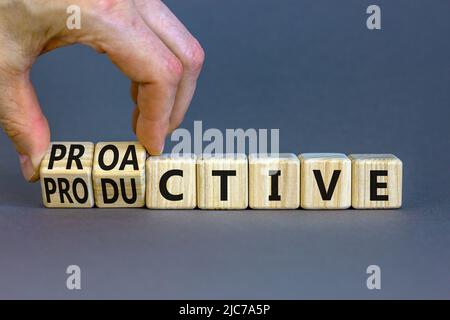 Simbolo proattivo e produttivo. L'uomo d'affari trasforma i cubi e cambia la parola di concetto produttiva a Proactive. Bellissimo sfondo grigio. Business pro Foto Stock