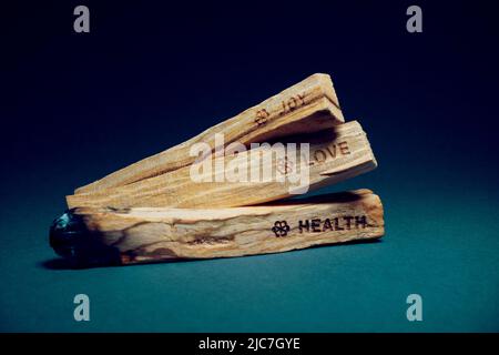 Bastoncini di palo Santo, usati per l'energia di guarigione. Scritto cuore, amore e gioia su di loro. Foto Stock