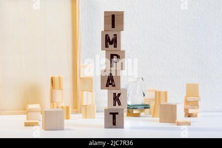 parola di impatto scritta sul blocco di legno. Foto Stock