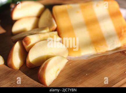 5 Formaggi inglesi a strati con mele in cucina rustica con luce naturale Foto Stock