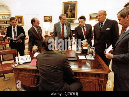 25 ottobre 1985, Washington, Distretto di Columbia, USA: In questa foto pubblicata dalla Casa Bianca, il Presidente degli Stati Uniti Ronald Reagan durante un incontro con il personale senior per quanto riguarda Grenada nell'Ufficio ovale della Casa Bianca a Washington, DC il 25 ottobre 1983. Raffigurato di fronte al presidente, da sinistra a destra: Ex ambasciatore degli Stati Uniti in Brasile Langhorne Motley, Vice Capo dello staff della Casa Bianca Michael Deaver, Consigliere del Presidente Edwin Meese, Segretario della Difesa degli Stati Uniti Caspar Weinberger, Segretario di Stato degli Stati Uniti George P. Shultz, e Consulente della sicurezza Nazionale degli Stati Uniti Robert McFarlane.ma Foto Stock